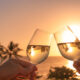 Wine glasses in a beautiful sunset beach setting.